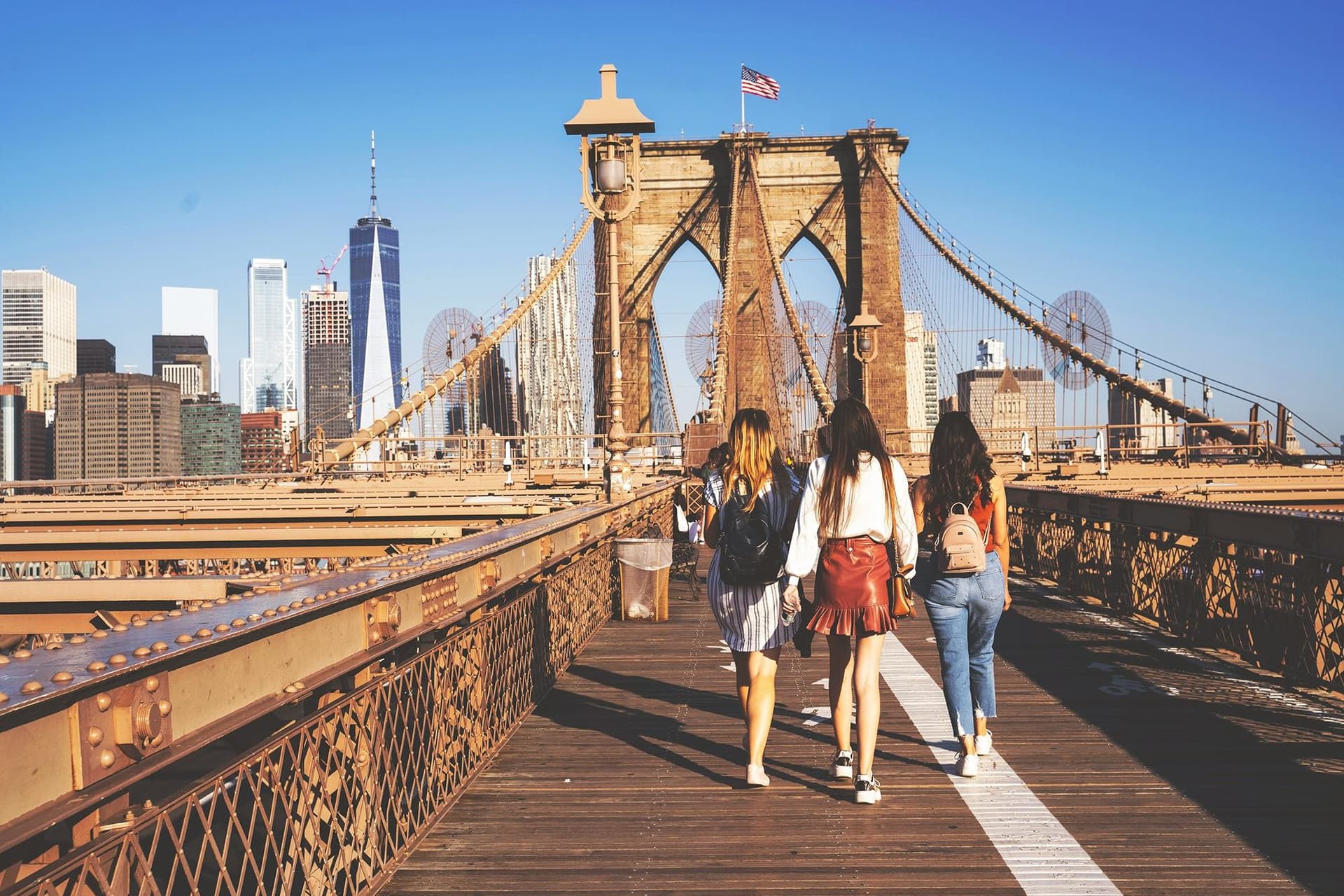 Studerende krydser Brooklyn Bridge under sprogkurser i New York med udsigt til Manhattan.